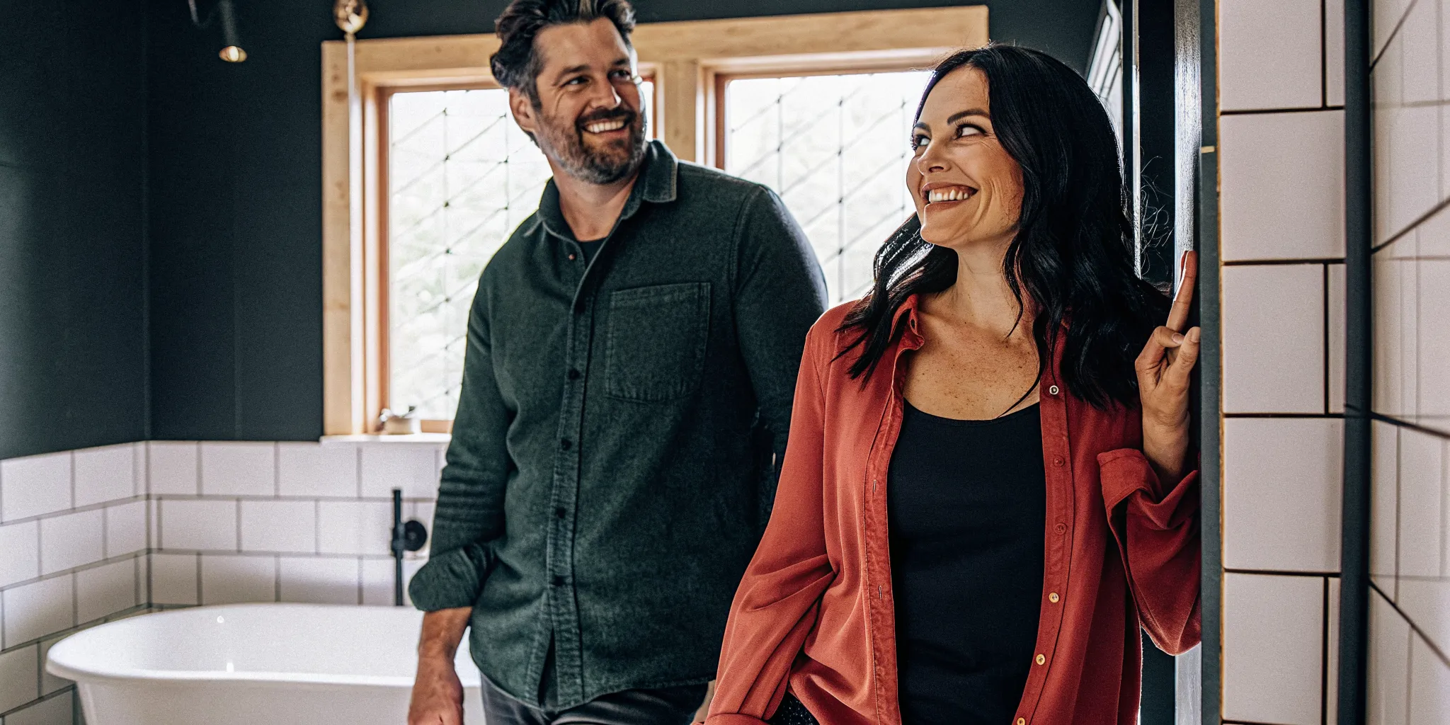 Happy couple in a new bathroom after hiring an affordable bathroom remodel company.