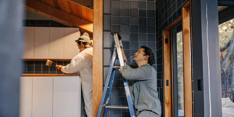 Professional house painters painting kitchen cabinets and walls for a flawless finish.